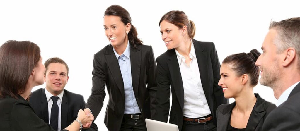 Pessoas fazendo uma reunião. A reunião é liderada por duas mulheres empresárias.