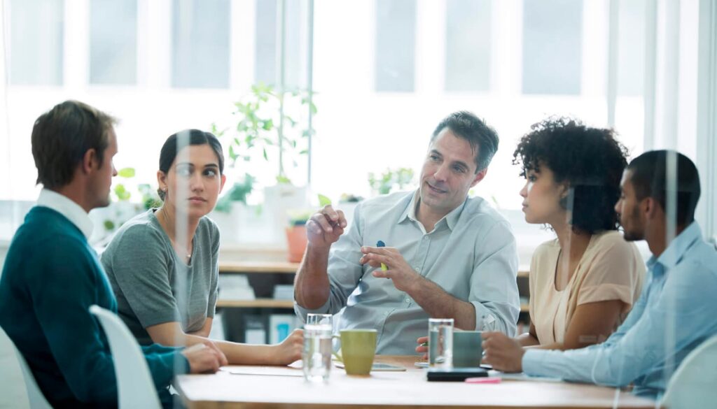 Cinco pessoas em uma reunião.