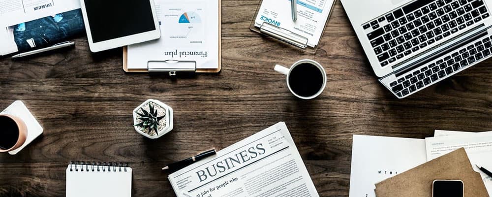 Mesa de escritório com café e jornal, marketing de conteúdos para advogados