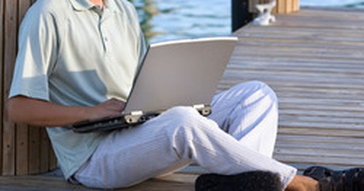 Homem sentado acessando notebook