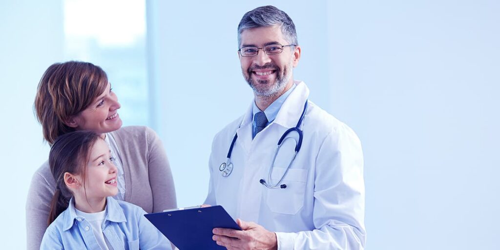 Um médico olhando para câmera e sorrindo