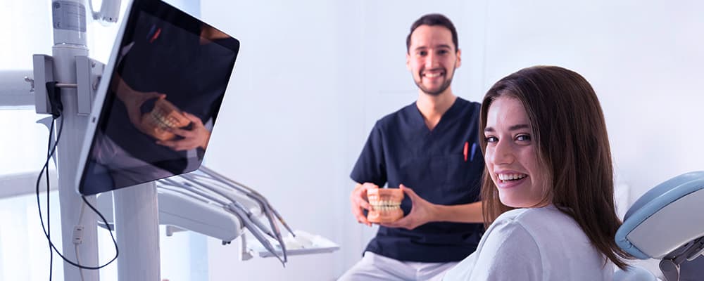 Um dentista conversando com o paciente sobre divulgação de clínica odontológica.